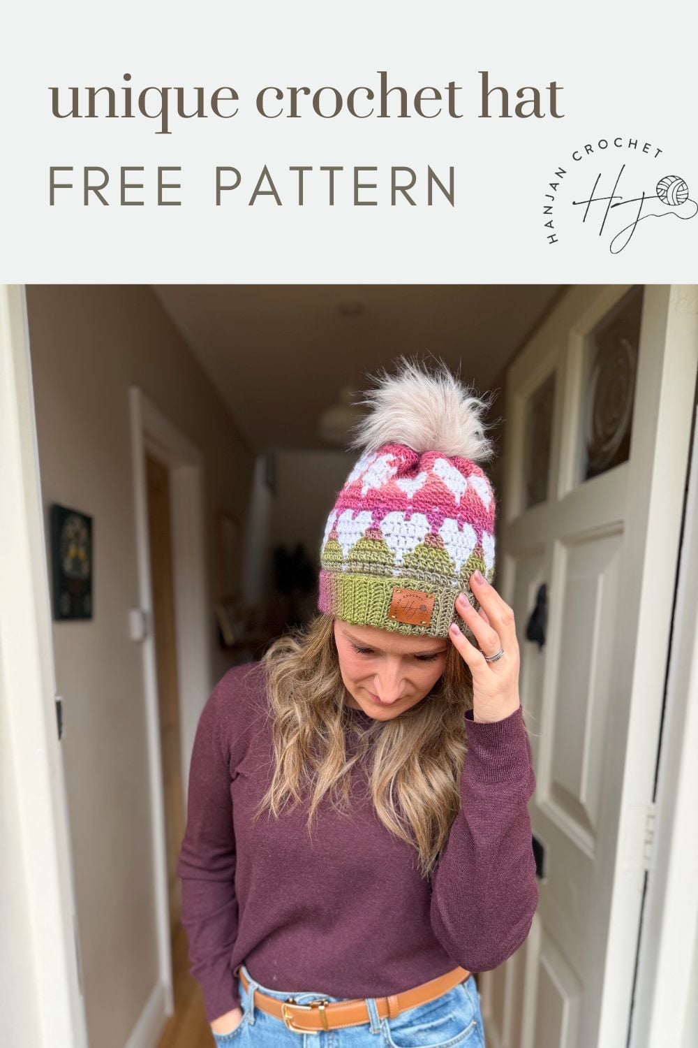 A woman wearing a pink, white, and green crochet hat with a pom-pom stands in a hallway, with text above her reading "unique crochet hat FREE Crochet Heart Hat Pattern.