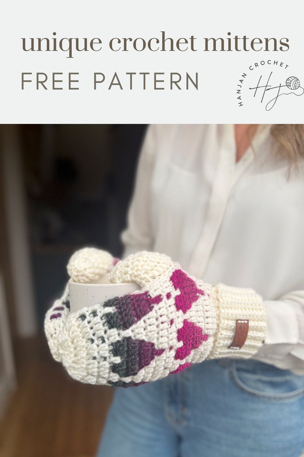 Person wearing off-white crochet heart mittens with pink and dark accents, holding a mug. Text above reads, "unique crochet mittens FREE PATTERN.