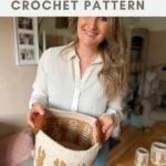 Woman holding a crocheted basket with bunny designs and leather handles in a cozy living room, showcasing a charming crochet bunny basket pattern for stylish home storage.