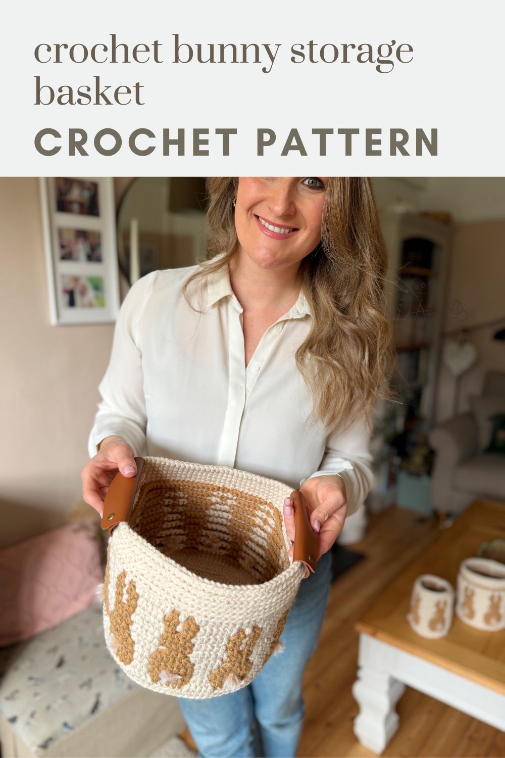 Woman holding a crocheted basket with bunny designs and leather handles in a cozy living room, showcasing a charming crochet bunny basket pattern for stylish home storage.