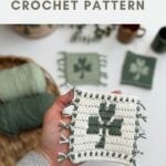 Person holding a crocheted square with a green shamrock design and fringe, plus yarn and finished squares in the background. Text reads "crochet shamrock coaster CROCHET PATTERN.
