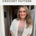 A woman stands indoors wearing a white crochet wrap over a beige top and jeans. Text above reads "cluster stitch wrap CROCHET PATTERN.