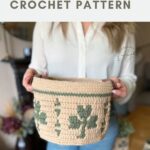 Person holding a large, beige crochet basket with green leaf patterns; text above reads "large crochet basket CROCHET PATTERN.