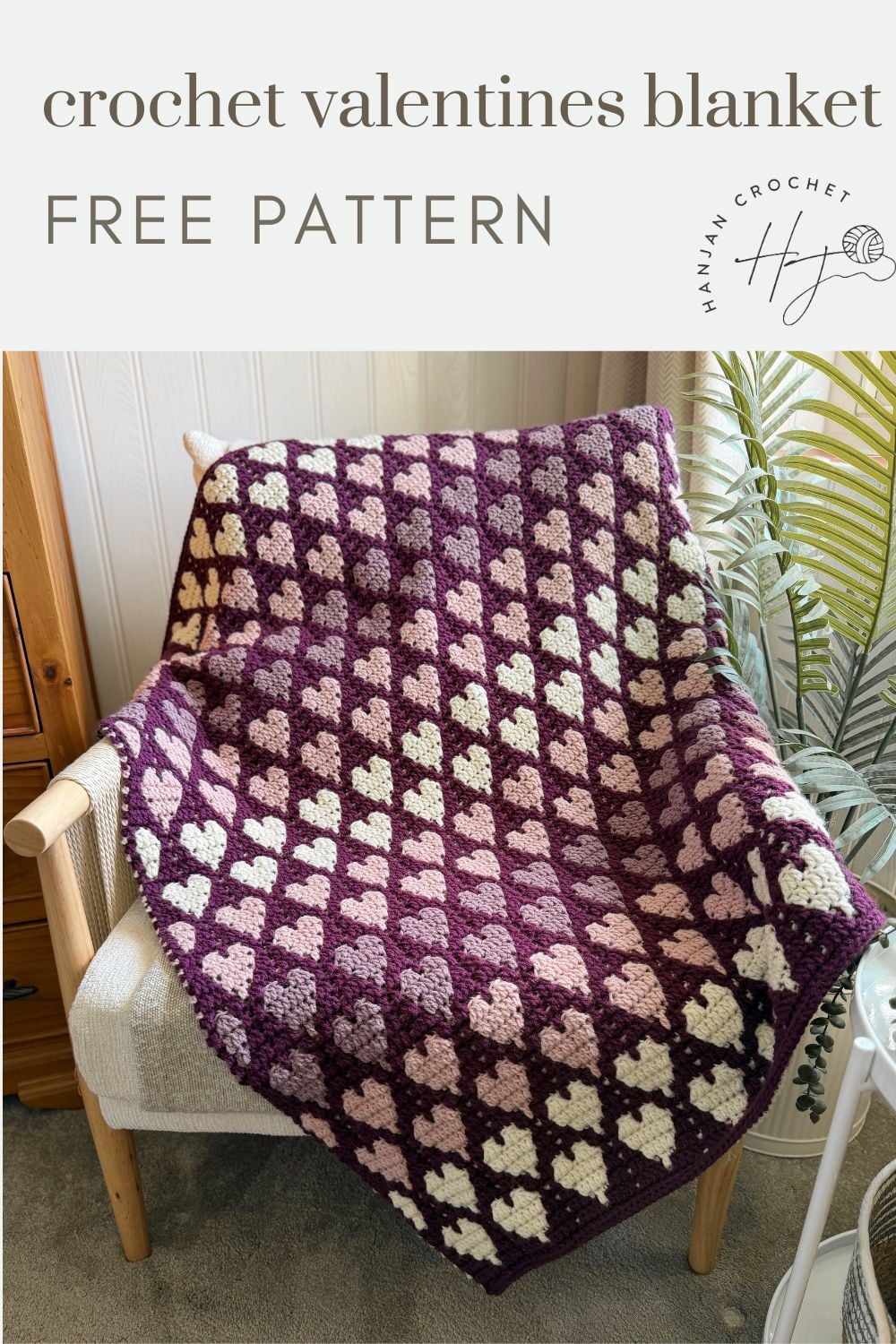 A crochet blanket with a repeating heart pattern in shades of burgundy, pink, and cream is draped over a chair. Text above reads "crochet valentines blanket free pattern.