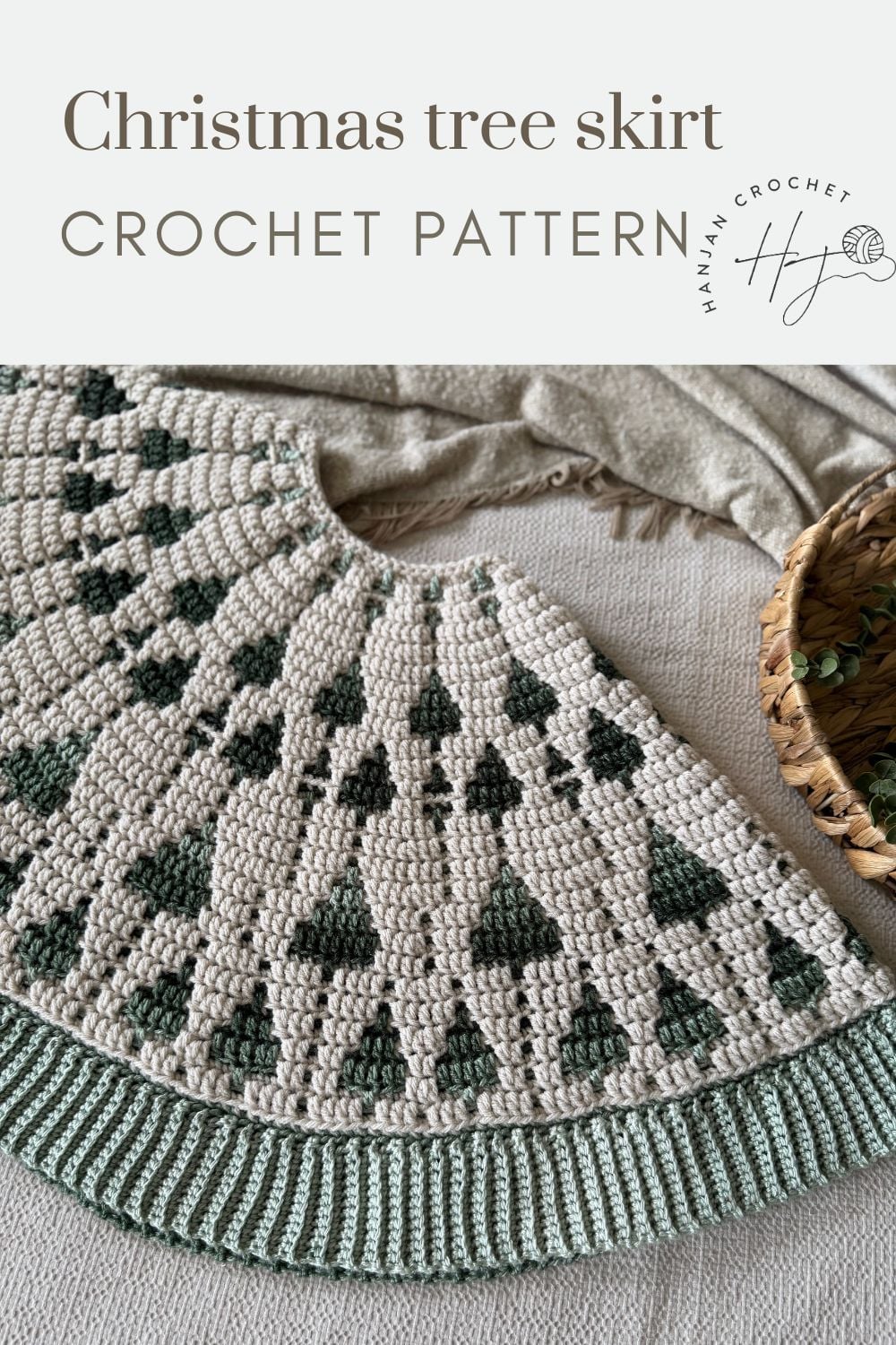 Crocheted Christmas tree skirt with a pattern of green trees on a cream background, displayed partially folded on a beige surface next to a wicker basket. Text reads "Crochet tree skirt pattern.