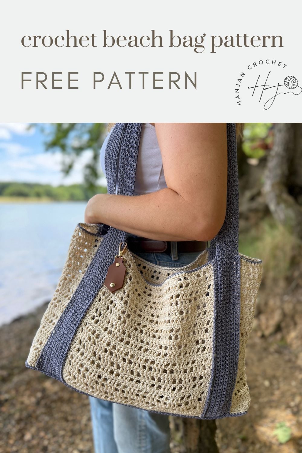 Person carrying a two-toned crochet beach bag with blue straps and a tan body, standing outdoors near water and trees. Text above reads "free crochet beach bag pattern – FREE PATTERN.