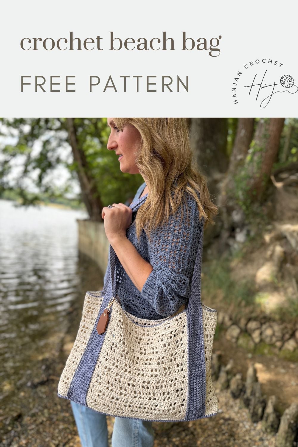 Woman standing near a lake holding a crochet beach bag with blue straps; text reads “free crochet beach bag pattern.”.