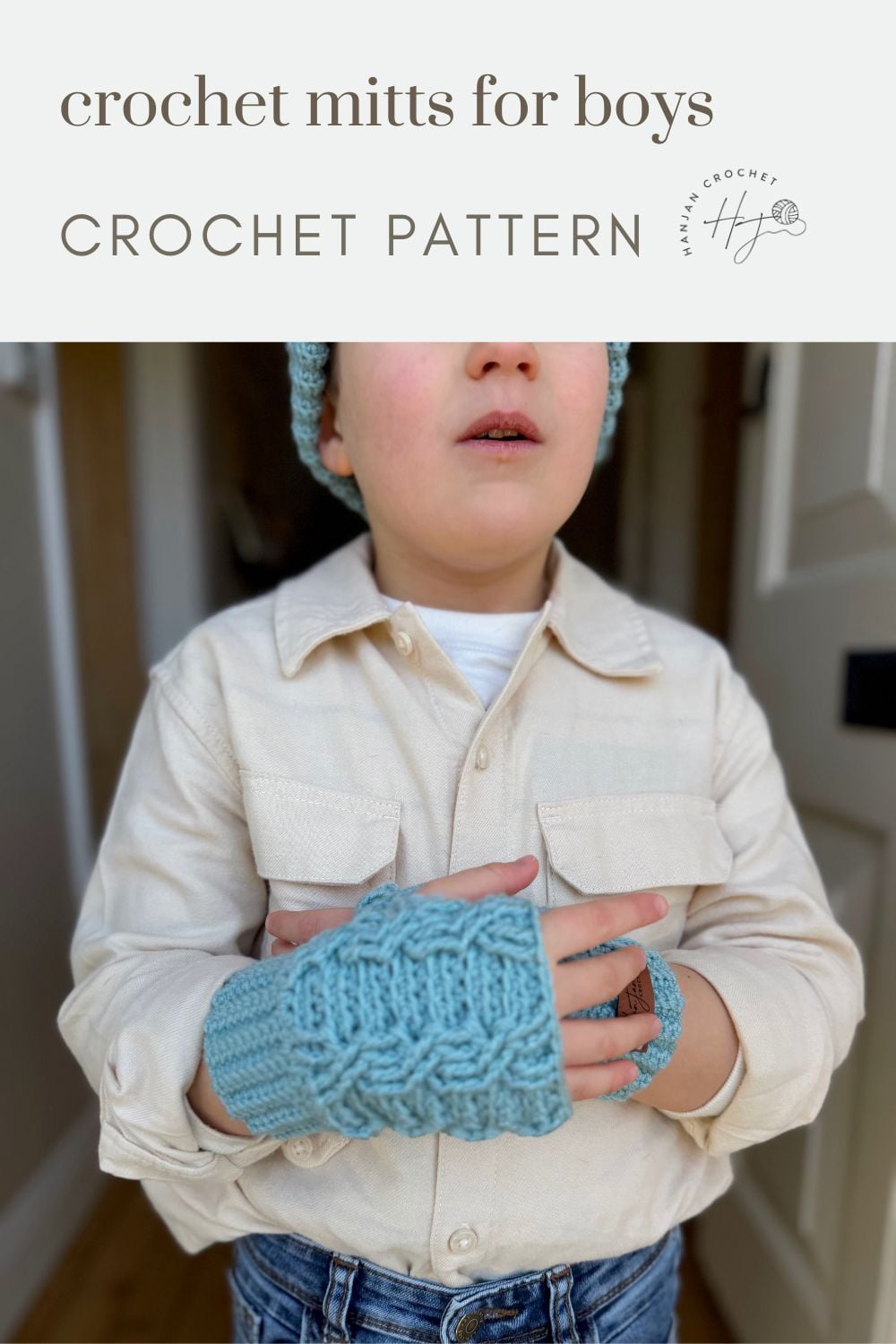 Young boy wearing a cream shirt and blue crochet wrist warmers, modeling a stylish boys’ mitts design—perfect for those searching for a crochet wrist warmers free pattern.