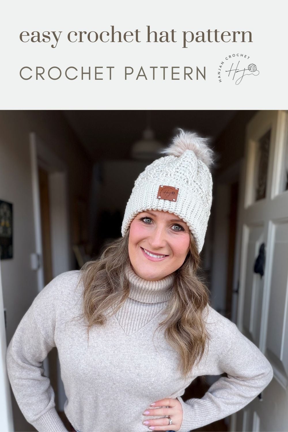 Woman wearing a white crocheted hat with a pom-pom, standing indoors and smiling; text above reads “easy crochet hat pattern CROCHET PATTERN.” Perfect for those searching for a free crochet cable hat pattern.