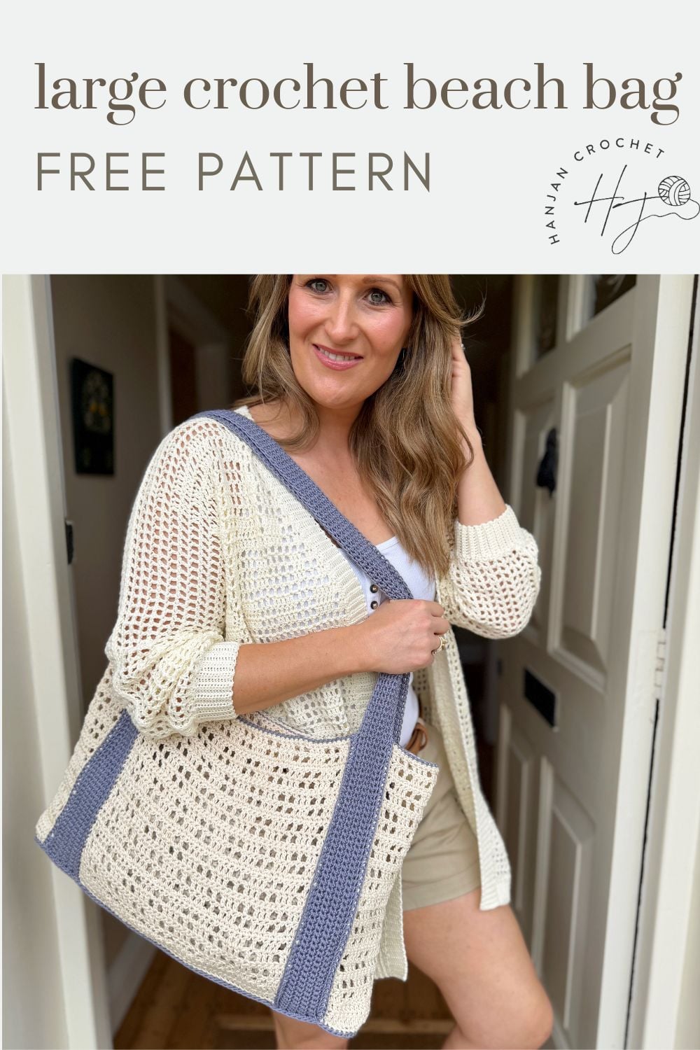 Woman standing indoors holding a large crochet beach bag with blue handles and trim, wearing a cream cardigan and beige shorts. Text above reads "large crochet beach bag free crochet beach bag pattern.