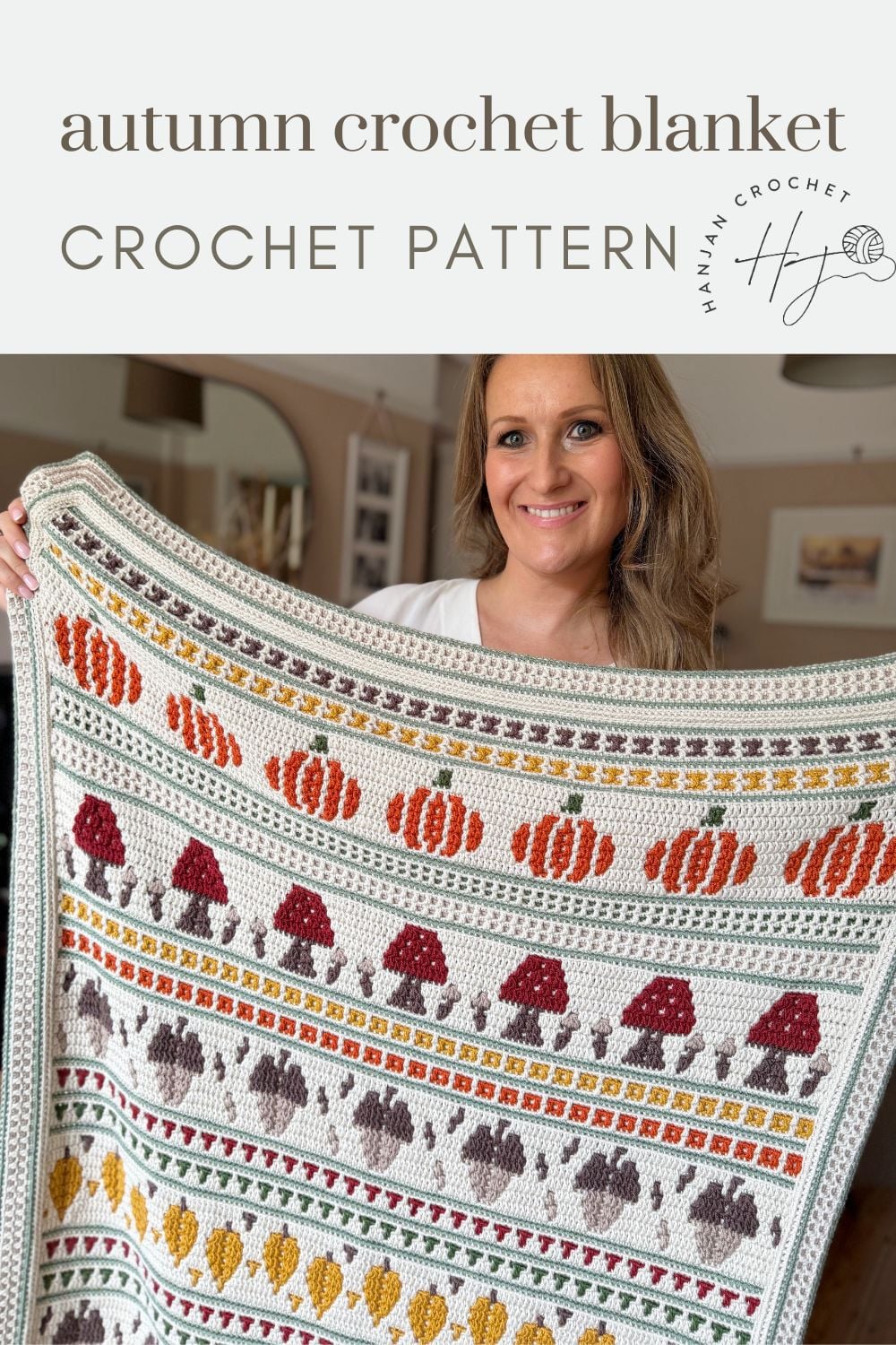 Woman holding a crocheted blanket with autumn-themed patterns in red, orange, yellow, and brown; text reads “autumn crochet blanket crochet pattern.”.