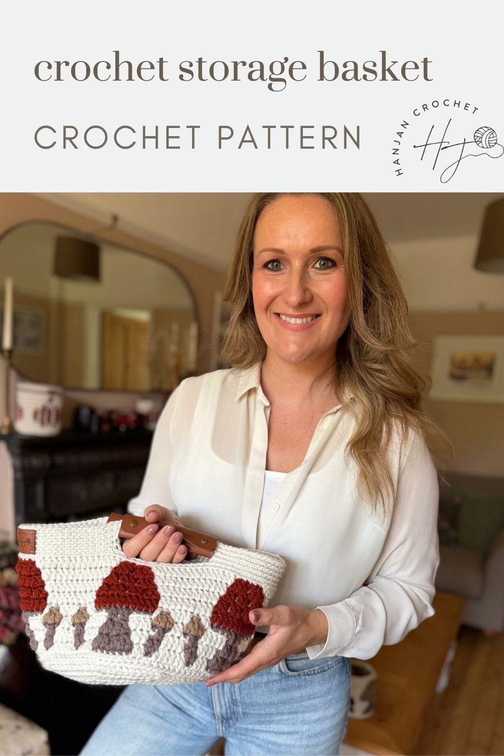 Woman standing in a living room holding a handmade crochet storage basket with a mushroom pattern, under text reading “crochet storage basket pattern.”.
